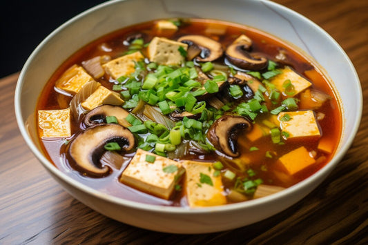 Soupe au tofu avec légumes et champignons sur une table en bois.